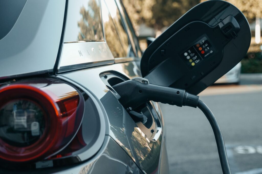 Close-up of an electric vehicle being charged, highlighting modern clean energy technology.